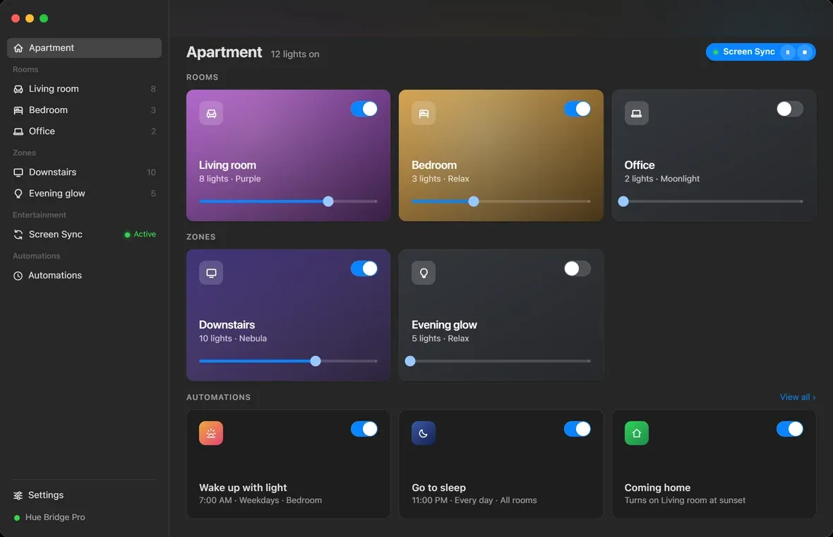 Hue Sync on macOS: a sidebar of rooms and zones beside a dashboard of room cards, each tinted its current color with a brightness slider