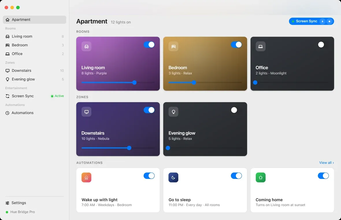 Hue Sync on macOS: a sidebar of rooms and zones beside a dashboard of room cards, each tinted its current color with a brightness slider