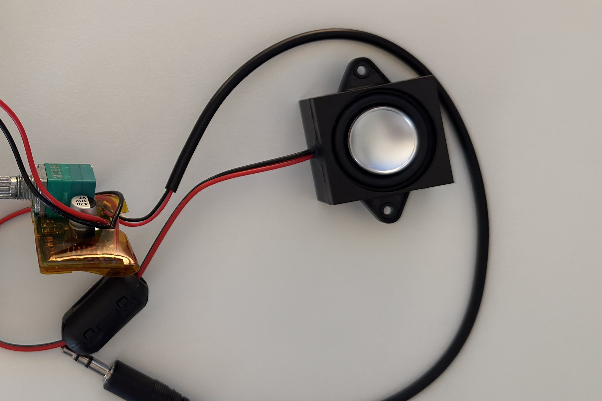 The audio chain: the amplifier board, a USB audio dongle with a 3.5mm plug, and a single round speaker