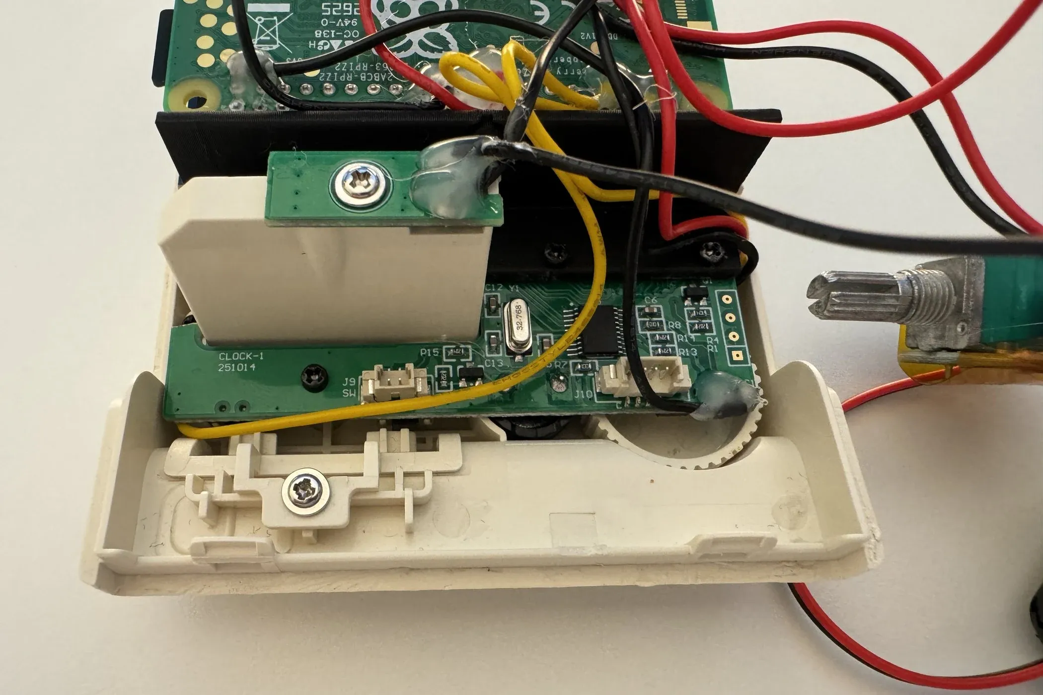 Inside the front of the shell: the button boards and their wiring, with the rotary encoder's knurled shaft at the right